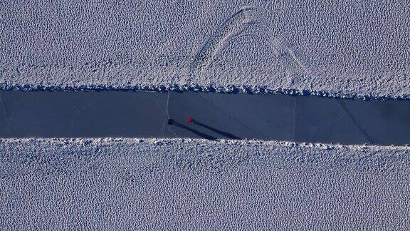 在一个阳光明媚的冬日里一对夫妇在湖上的厚冰上滑冰