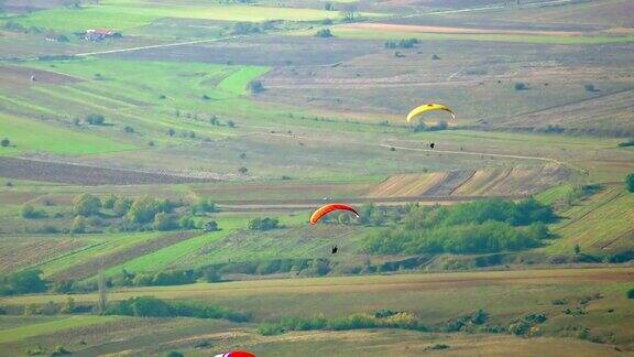 滑翔伞在绿色的景观上滑翔
