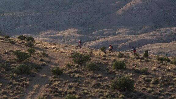 四个骑山地自行车的人在沙漠山上
