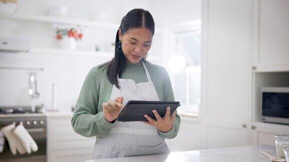 厨房连接和女人用平板电脑打字和社交媒体与在线阅读食谱和思考准备一顿饭女孩或日本人与技术家庭和互联网搜索信息