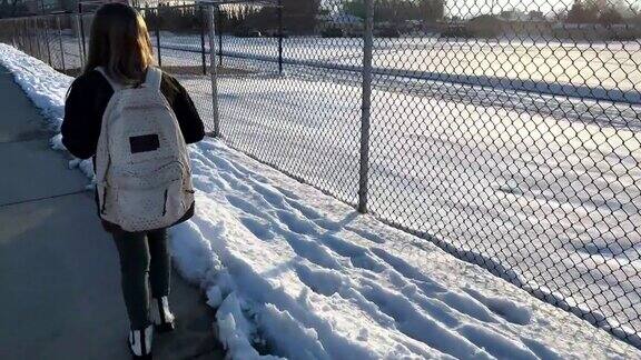 冬天里一个小女孩正走向教学楼