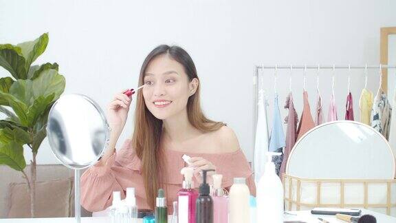 美丽的亚洲女人博客展示如何化妆和使用化妆品在摄像机前录制在家的视频直播商业在线影响者对社交媒体