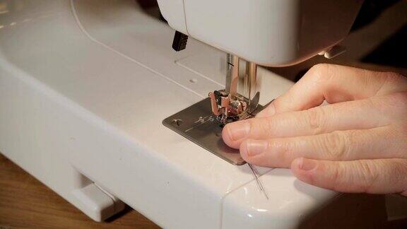 特写镜头一个年轻人在纺织工作室做裁缝使用缝纫机使领结