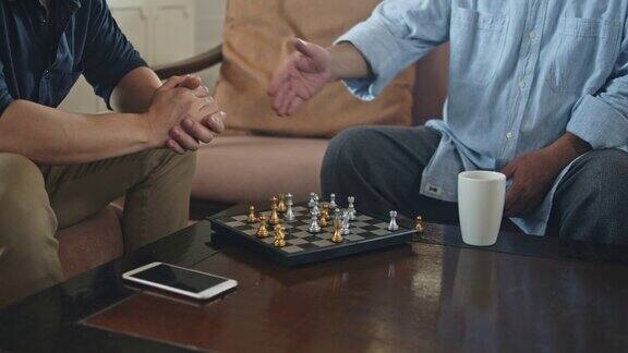 年迈的父亲和年幼的儿子一起在家里下棋