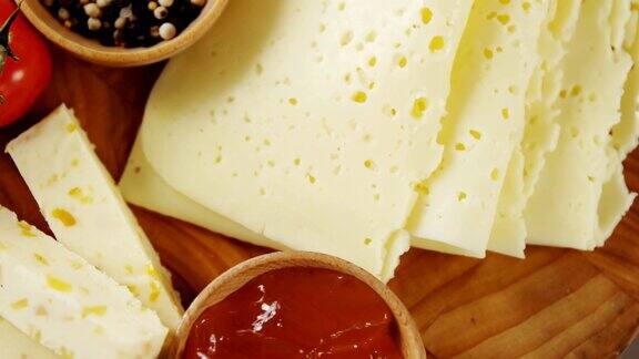 不同种类的奶酪西红柿和一碗果酱和香料