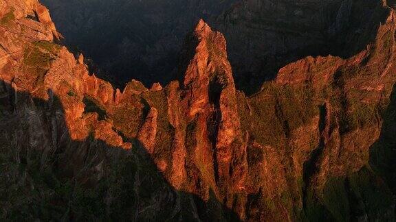 景观的岩石范围悬崖与橙色日落天空在地平线上