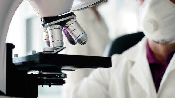 科学家研究人员在实验室用显微镜工作