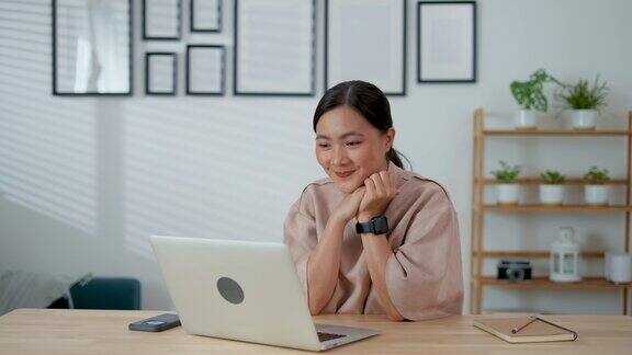 亚洲女性在家里办公室用笔记本电脑进行视频通话