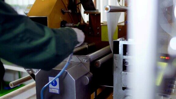 工人用吸尘器清理工厂里的机器
