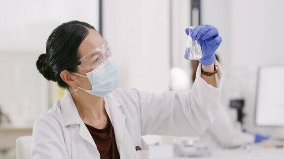 玻璃烧杯口罩和在制药实验室从事科学项目的女科学家研究、生物学和生物学家在实验室用化学液体容器进行科学发现