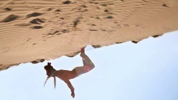 一个年轻的运动员在沙漠里做360度后空翻