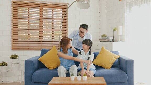 幸福的亚洲家庭在客厅的沙发上拥抱在一起