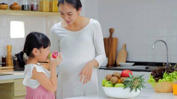 怀孕的母女在厨房做沙拉怀孕和生育