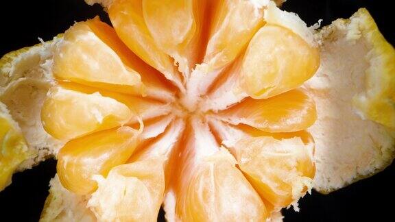 俯视图超级宏切成片的橘子在黑色背景上旋转多莉滑块