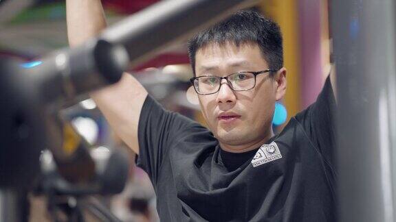 年轻的亚洲男子在健身房锻炼