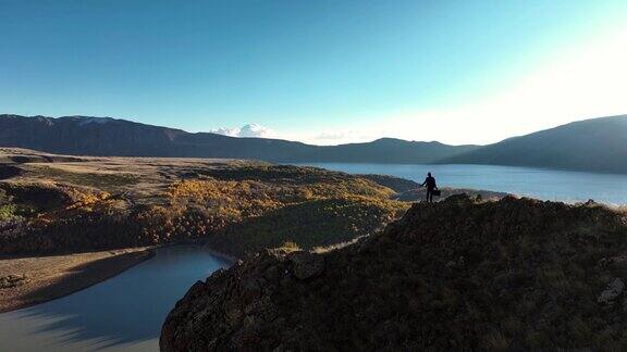 日落时分商人在岩石山顶徒步旅行