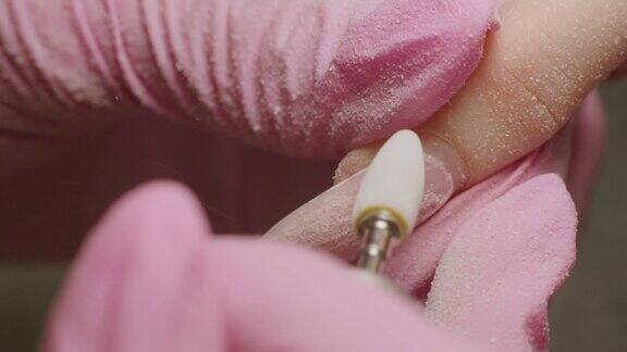 硬件修指甲去除材料熟练掌握在spa沙龙进行指甲加工超微距拍摄女美甲师正在给客户锯指甲护理美容指甲美容院美甲服务