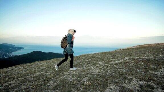 女徒步旅行者背着背包在山区行走