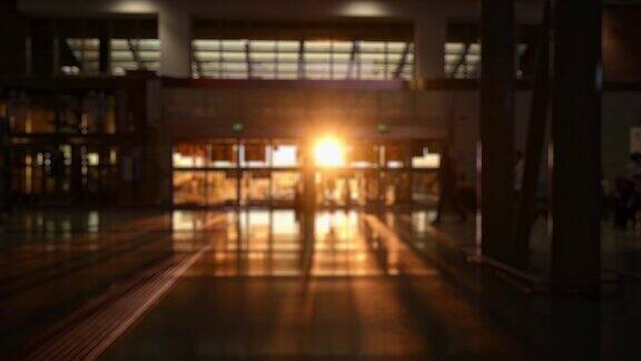 (离焦视频)日落时分一些游客在机场候机楼里行走的模糊剪影Covid-19大流行期间的旅行理念