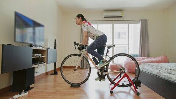 亚洲运动女性在家里锻炼自行车