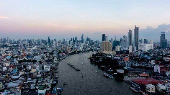 时间从早到晚流逝湄南河鸟瞰图曼谷市中心亚洲智慧城市的金融区和商业中心日落时分的摩天大楼和高层建筑