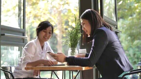 两个亚洲女人坐在咖啡店聊天