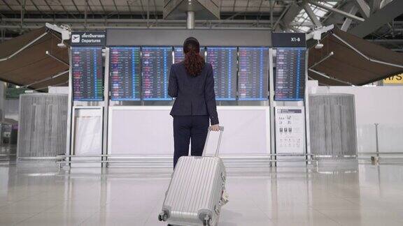 女士拿着行李在机场登机等待航班