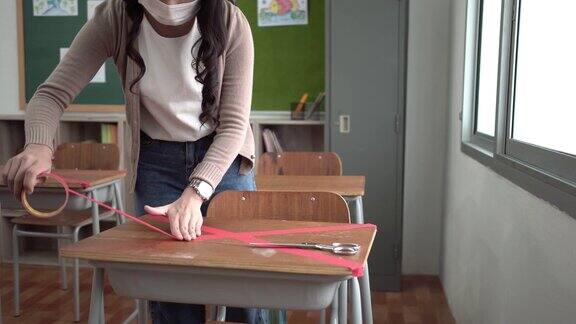 亚洲女教师在课桌上用交叉的符号批改红字