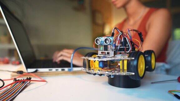 女程序员和机器人工程师通过Arduino平台测试带有传感器的自动驾驶机器人汽车原型
