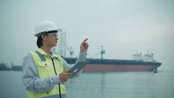 视频片段工程师检查工业港口背景上的手移动触摸屏