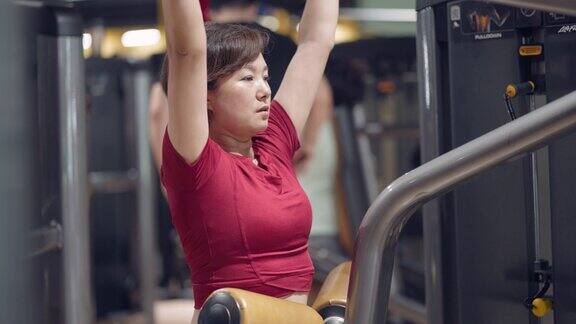 年轻的亚洲女性在健身房锻炼