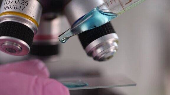 在化学实验室显微镜下检查蓝色液体特写4k电影慢动作