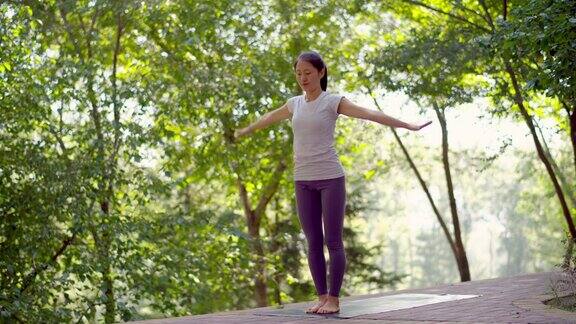 年轻的亚洲女性在城市公园练习瑜伽