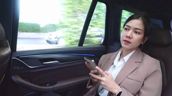 女子在汽车后座使用智能手机