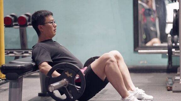 年轻的亚洲男子在健身房锻炼