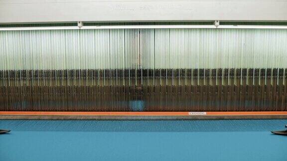 纺织工厂编织自动织布机工作中的零件特写镜头纺织厂设备工业机器正在释放梭织织物