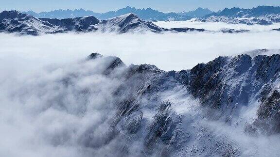 令人惊叹的空中冬季景观雪山山脉云雾蓝天下的中国四川嘉金山