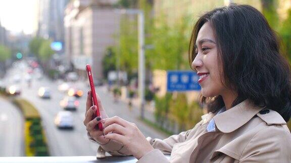 一个非常快乐的年轻亚洲女人在中国成都的一个下午用手机视频聊天的慢镜头