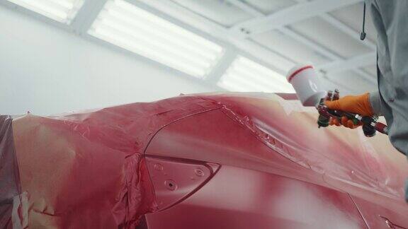 汽车喷漆工在专用展台上给车门喷红漆在汽车维修车间喷漆汽车零件汽车制造厂汽车油漆服务优质汽车车身店理念