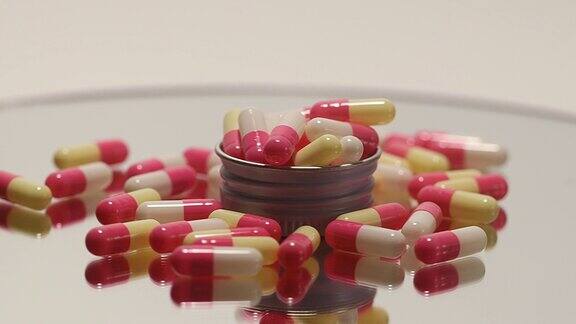 粉色、白色药丸和药瓶放在一个旋转平台上