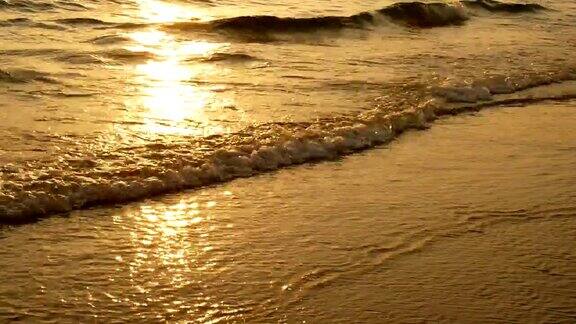 4K惊人的日落在热带海滩上海边沙滩上的海浪在日落时分阳光反射在水面上美丽的黄昏自然海洋背景