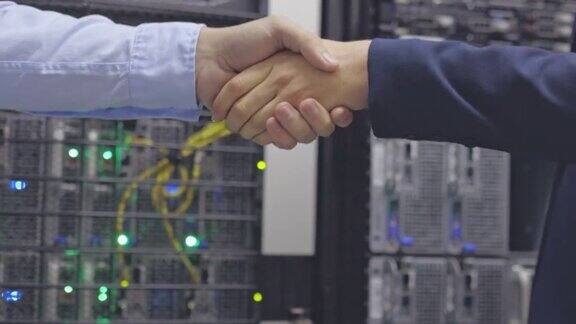 4k视频记录了两名不知名的IT技术人员站在一起在服务器室握手
