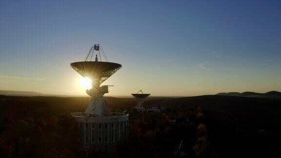 无人机在日落时拍摄的电信天线或无线电望远镜卫星天线