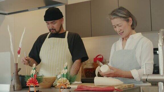 老年妇女和她的成年儿子一起准备传统的日本新年食物