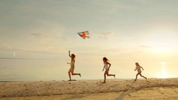 妈妈带着两个女儿在沙滩上放风筝乐趣在一起快乐的童年