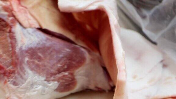 在肉类加工厂屠夫正在用刀切生猪肉
