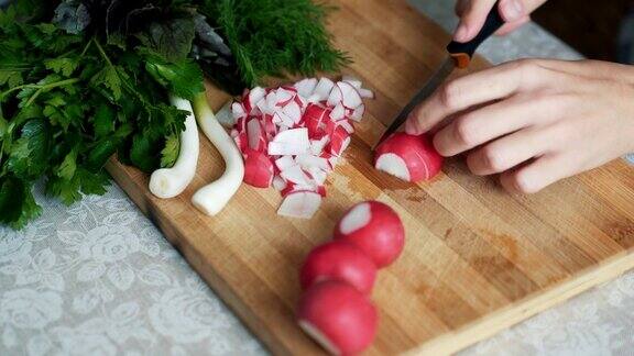 近距离女子用刀在木板上切萝卜概念的蔬菜