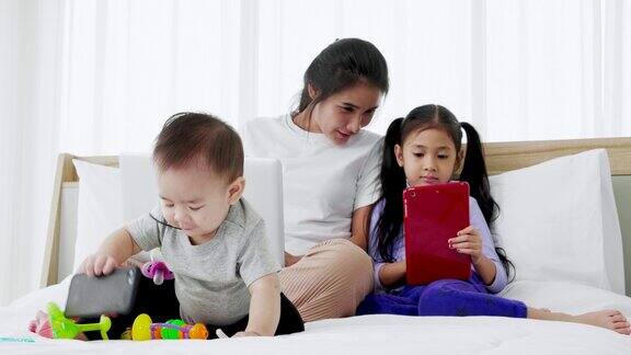 忙碌的母亲与两个女儿同时处理笔记本电脑超级妈妈