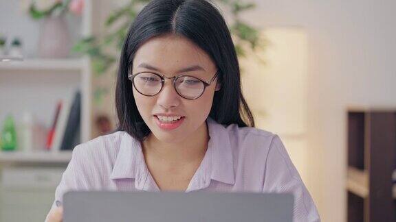 微笑的亚洲女性正在笔记本电脑上进行在线视频会议远程工作