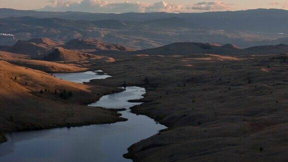 宁静的黄昏:空中全景草原湖泊和迷人的山